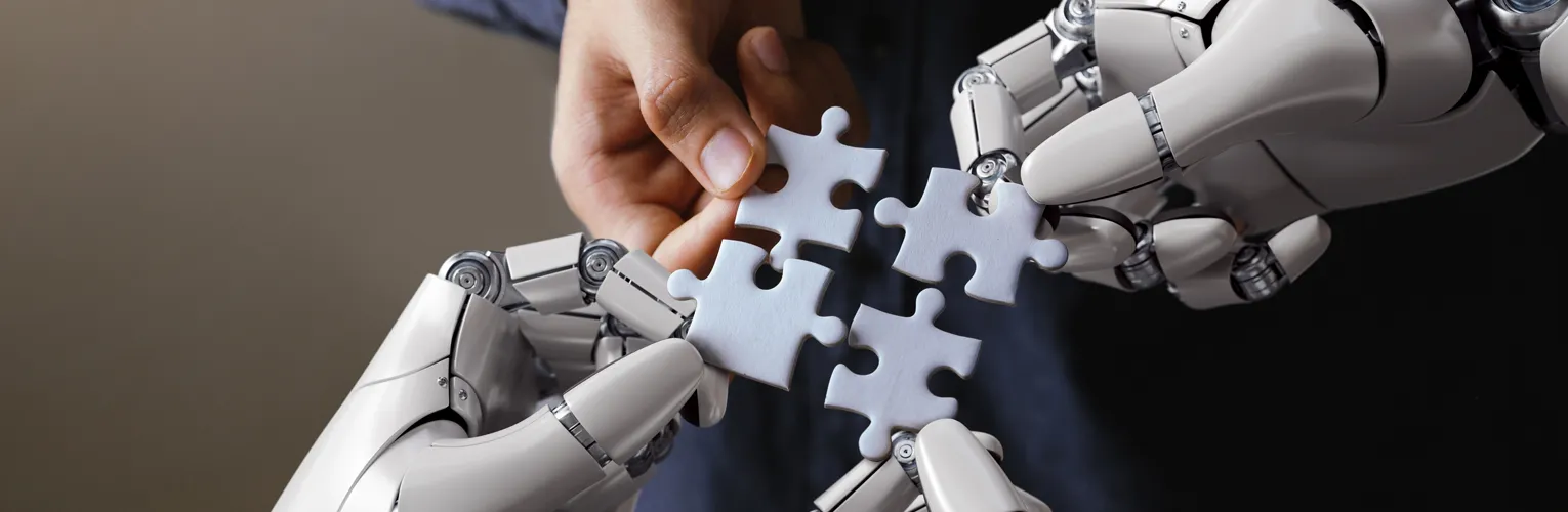 Human hand and robotic hands fitting puzzle pieces together to symbolise AI-assisted content creation